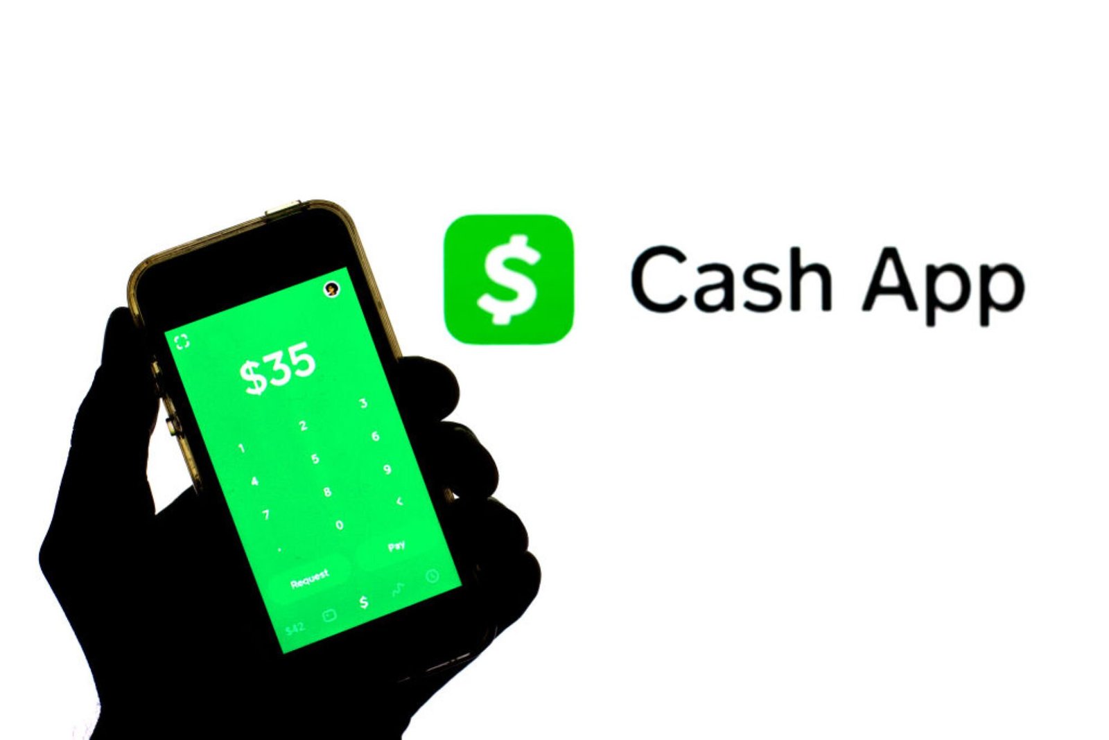 A silhouetted hand holding a smartphone displaying Cash App next to the Cash App logo. 